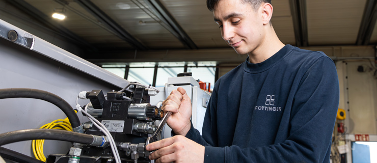 Lehrling bei der Montage einer Hydraulikanlage