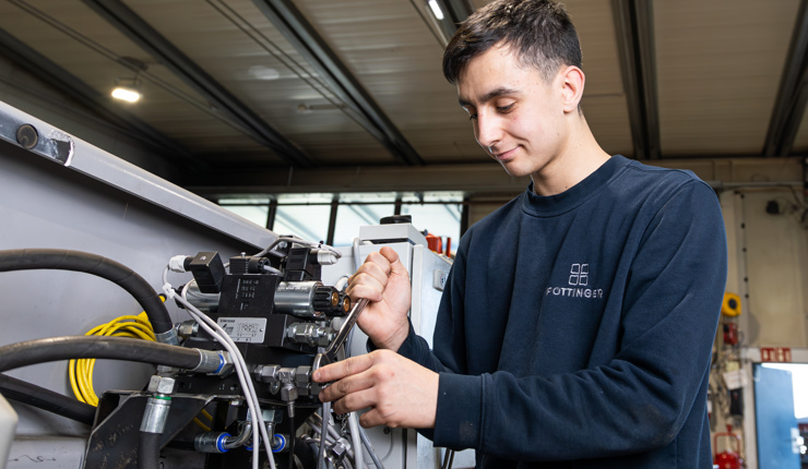 Lehrling bei der Montage einer Hydraulikanlage